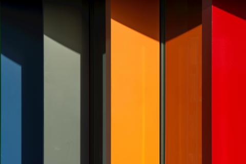 The colorful side of a building, with red, orange, green and blue panels