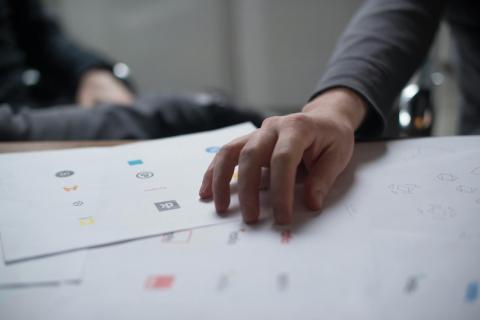 A hand touching paper with many logos on it