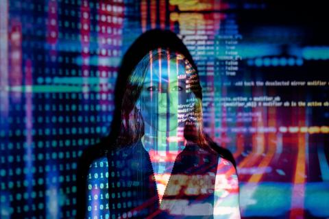 A woman standing in front of a wall with technological projections on it