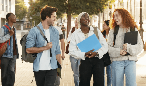 A group of students outside smiling and talking to each other